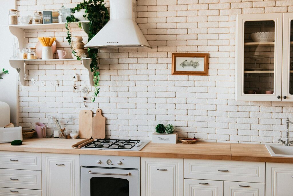 pexels-photo-2062426-2062426-3 Stylish kitchen interior with modern appliances, wooden counters, and greenery accents.